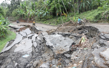 Pengendara sepeda motor melintasi jalan nasional Bireuen–Takengon yang amblas di Bireuen, Aceh, Senin (15/12/2025). Hujan deras akhir November memicu puluhan longsor dan amblas, mengganggu akses menuju Bener Meriah. (Foto: ANTARA FOTO/Irwansyah Putra/tom).